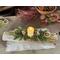A Christmas yule log centerpiece with a battery candle, oranges slcies, jingle bells and real touch greenery